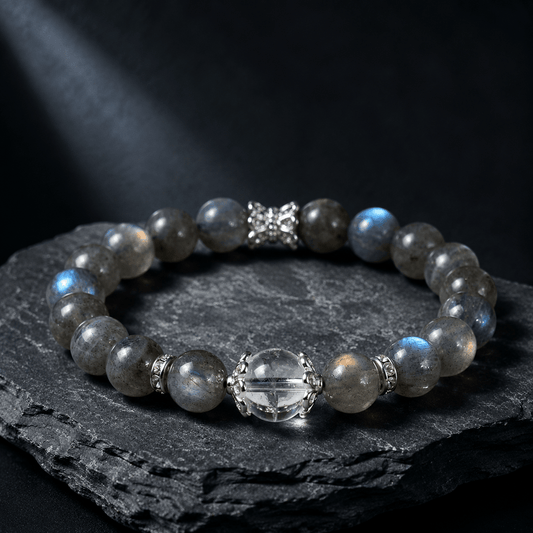 Blue Gray Moonstone and Clear Quartz bracelet displayed on black rock with silver-tone accent details