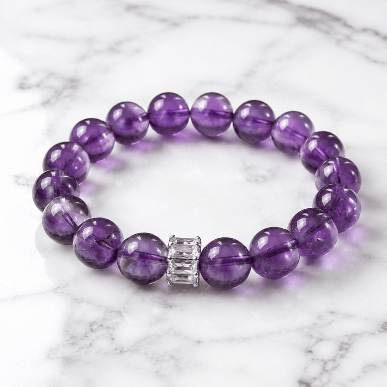 A Clear Way Through Amethyst bracelet displayed on white marble with deep purple 10mm beads