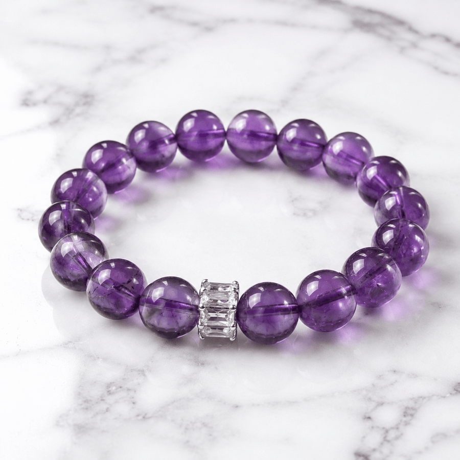 A Clear Way Through Amethyst bracelet displayed on white marble with deep purple 10mm beads