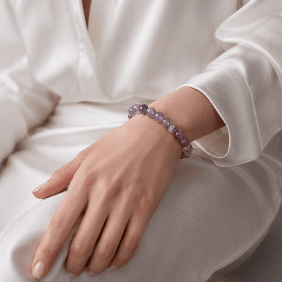 Woman wearing A Quiet Return 10mm Amethyst bracelet with a white blouse