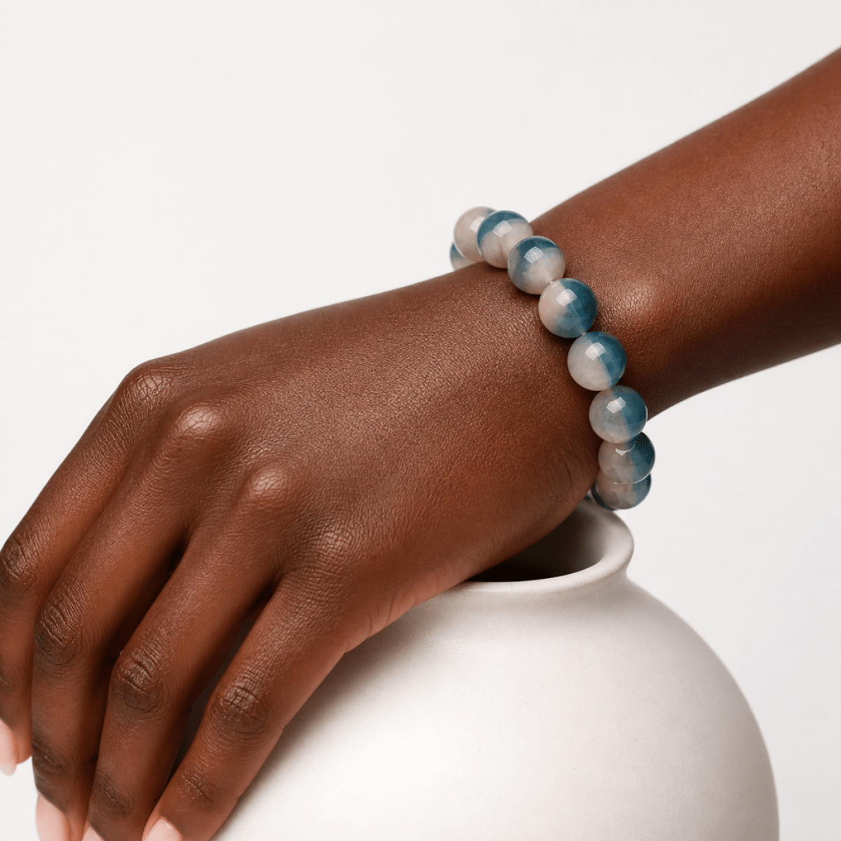 Natural Blue Fluorite bracelet worn on the wrist beside a white ceramic vase