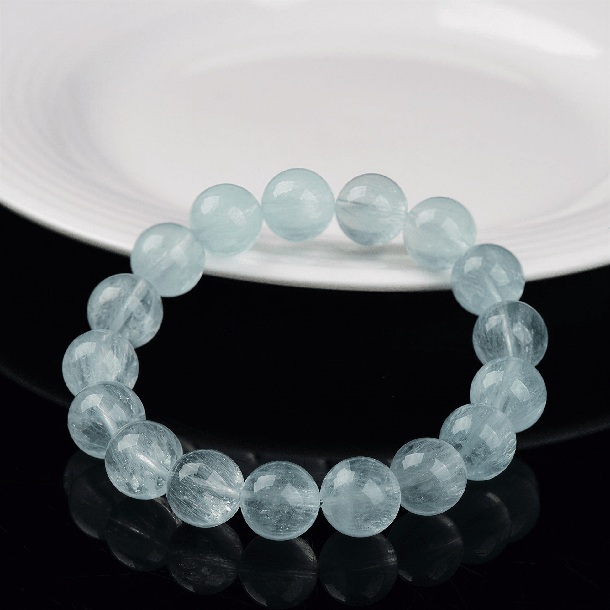 12mm Green Fluorite bracelet displayed on a black reflective surface