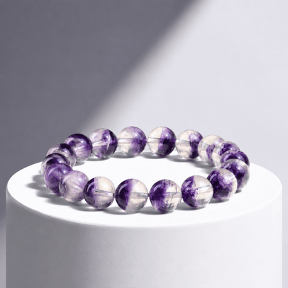 Natural Purple Fluorite bracelet displayed on a white pedestal in directional light