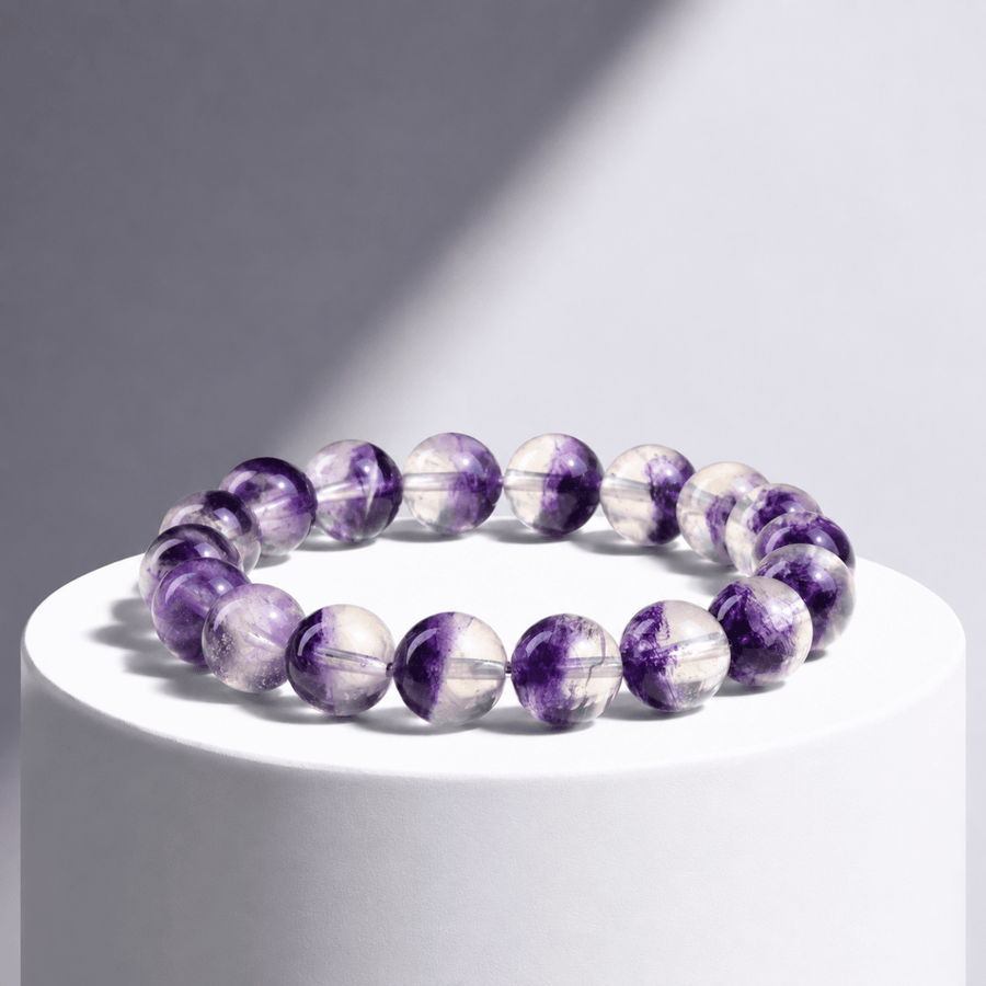 Natural Purple Fluorite bracelet displayed on a white pedestal in directional light