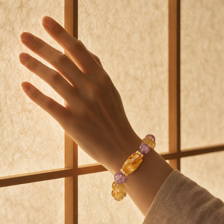 Natural Citrine and Amethyst bracelet worn on wrist beside warm paper window light