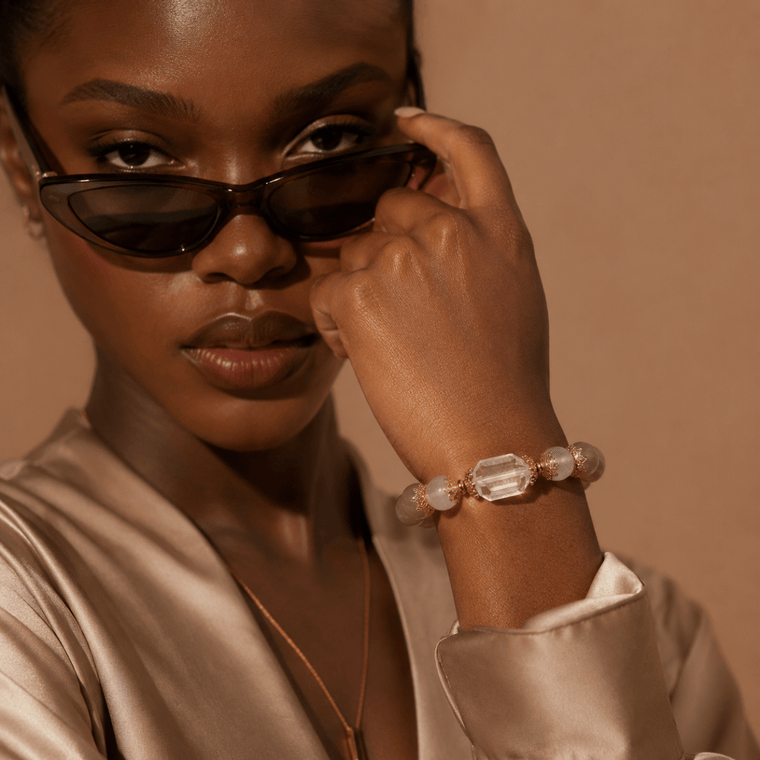 Model wearing Gray Moonstone and Clear Quartz bracelet with sunglasses and warm gold styling