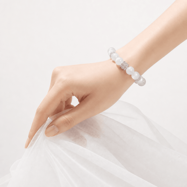 Moonstone bracelet worn on wrist with soft white tulle fabric and silver-tone spacer details