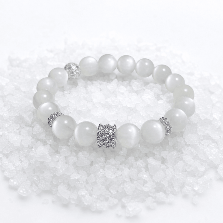 Natural Moonstone bracelet displayed on white crystal stones with silver-tone accents