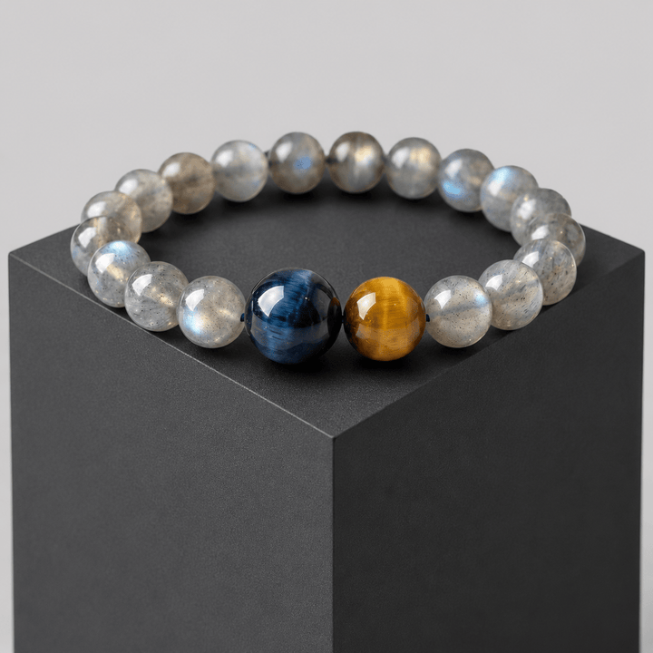 Gray Moonstone and Tiger Eye bracelet displayed on a black cube with blue and gold focal beads
