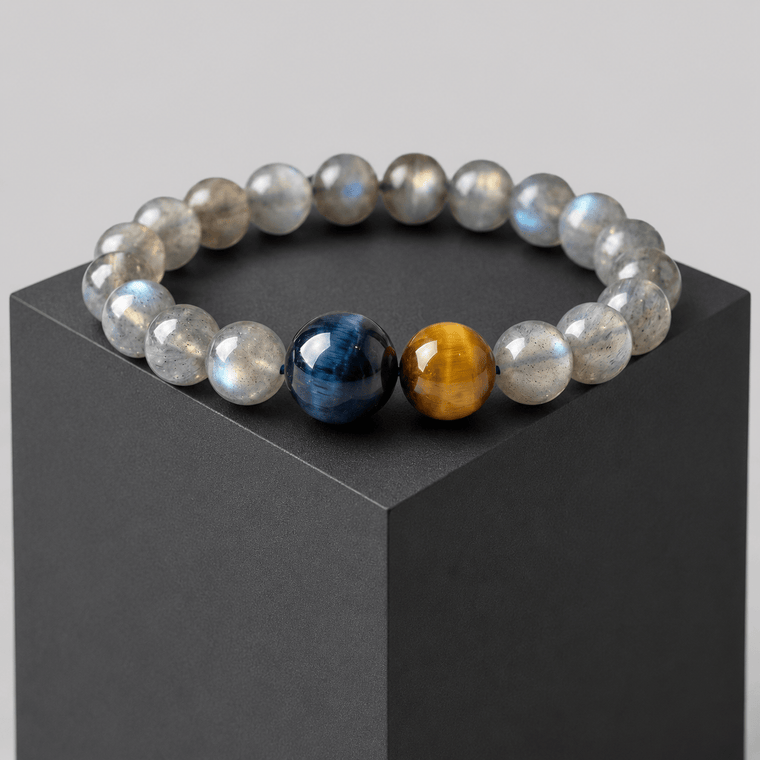 Gray Moonstone and Tiger Eye bracelet displayed on a black cube with blue and gold focal beads
