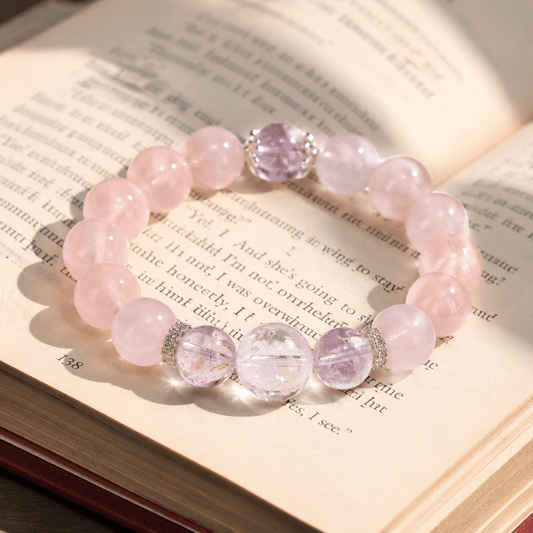I Let Love In bracelet with Mozambique Rose Quartz and Amethyst beads displayed on an open book