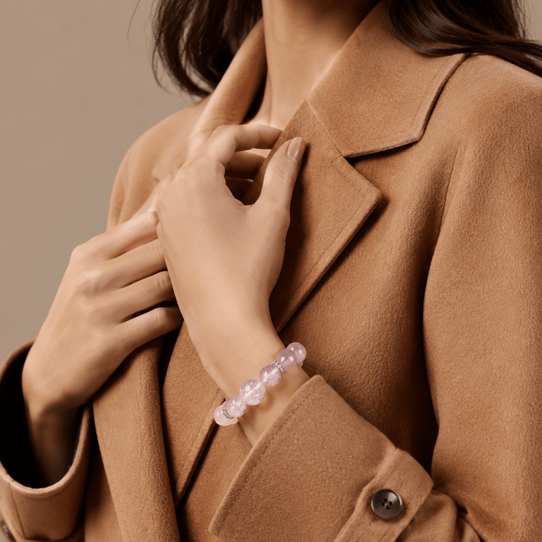 Woman wearing I Let Love In Rose Quartz bracelet with Amethyst accents and camel coat styling
