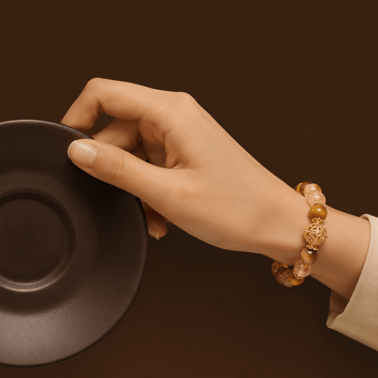 I Move With Courage crystal bracelet worn with a dark coffee cup in a warm brown setting