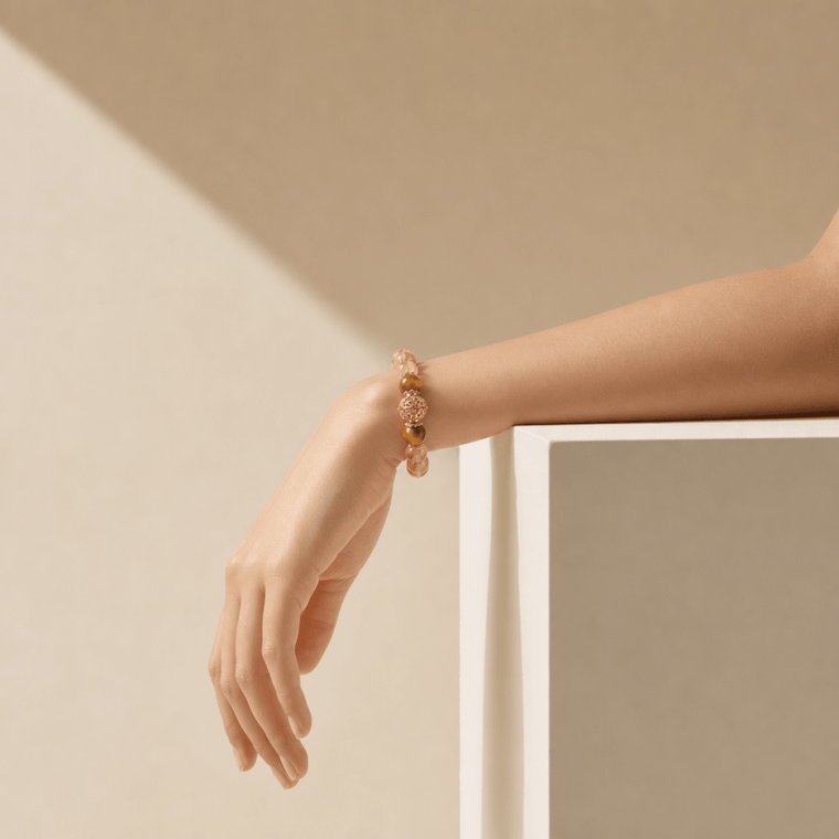 Minimal wrist view of Citrine and Tiger's Eye bracelet in a soft beige architectural setting