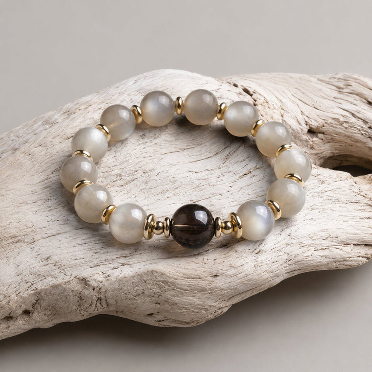 Gray Moonstone bracelet with Smoky Quartz center bead displayed on pale driftwood