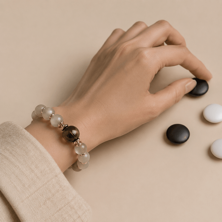 Gray Moonstone bracelet with Smoky Quartz focal bead worn while playing a black and white board game