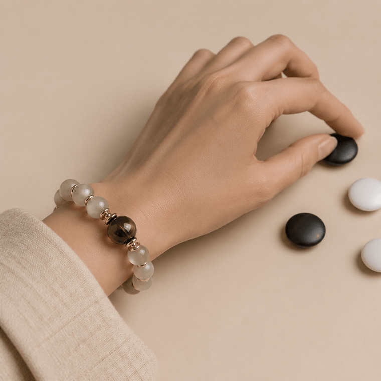 Gray Moonstone bracelet with Smoky Quartz focal bead worn while playing a black and white board game