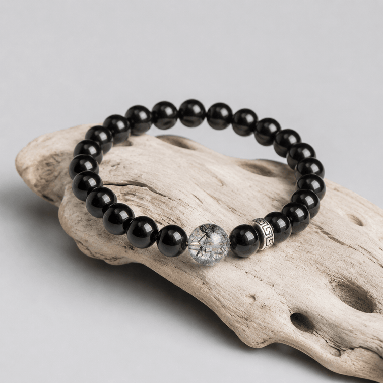 I Stand Clear Obsidian bracelet displayed on driftwood with Black Rutilated Quartz focal bead