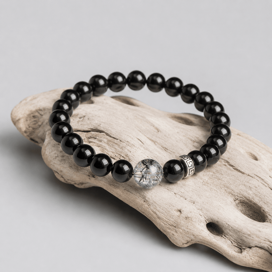 I Stand Clear Obsidian bracelet displayed on driftwood with Black Rutilated Quartz focal bead