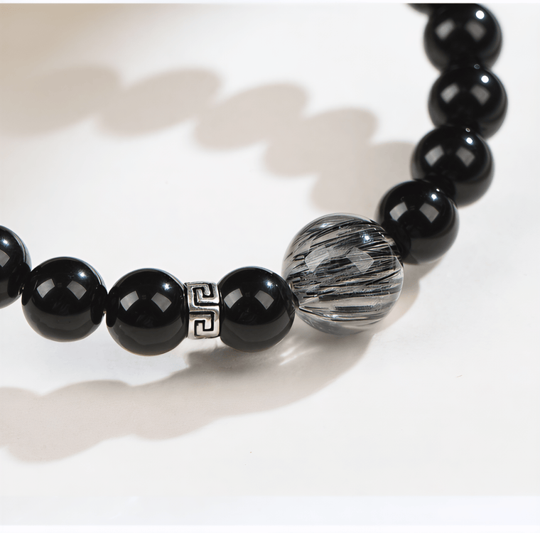 Detailed view of Black Rutilated Quartz focal bead, S925 silver accent, and natural Obsidian beads on I Stand Clear bracelet