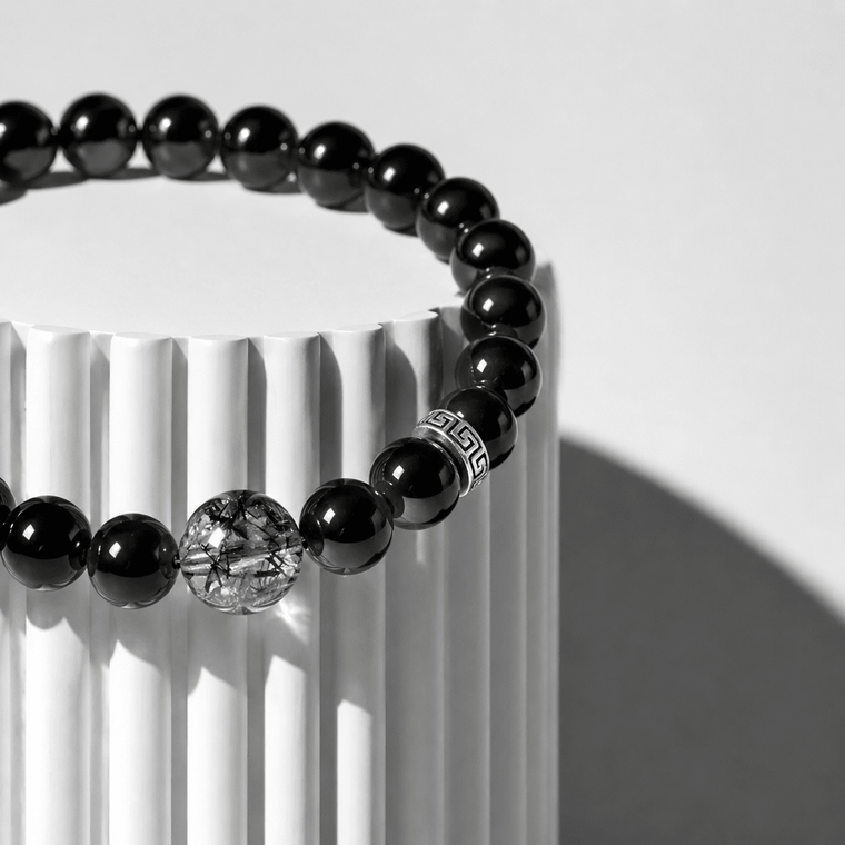 Close-up of I Stand Clear bracelet with glossy Obsidian beads, S925 silver accent, and Black Rutilated Quartz focal bead