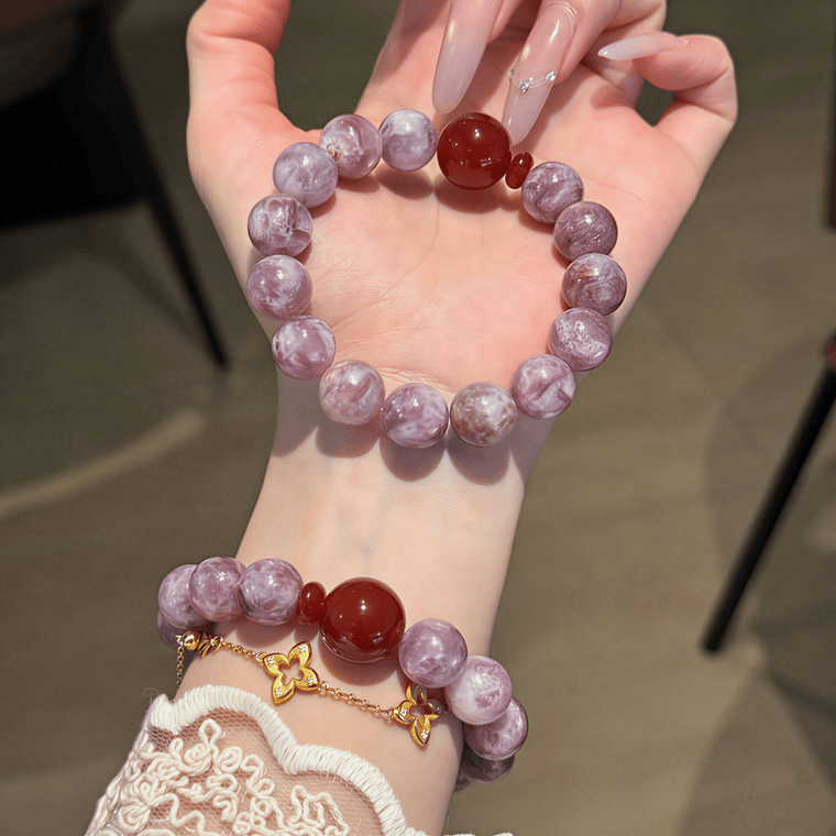 Hand holding I Trust My Fire bracelet showing 12mm natural Amethyst beads and red center bead