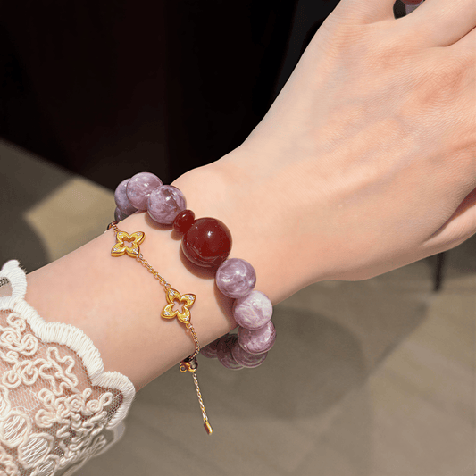 Close-up of a woman wearing I Trust My Fire bracelet with 12mm Amethyst beads and a red centerpiece