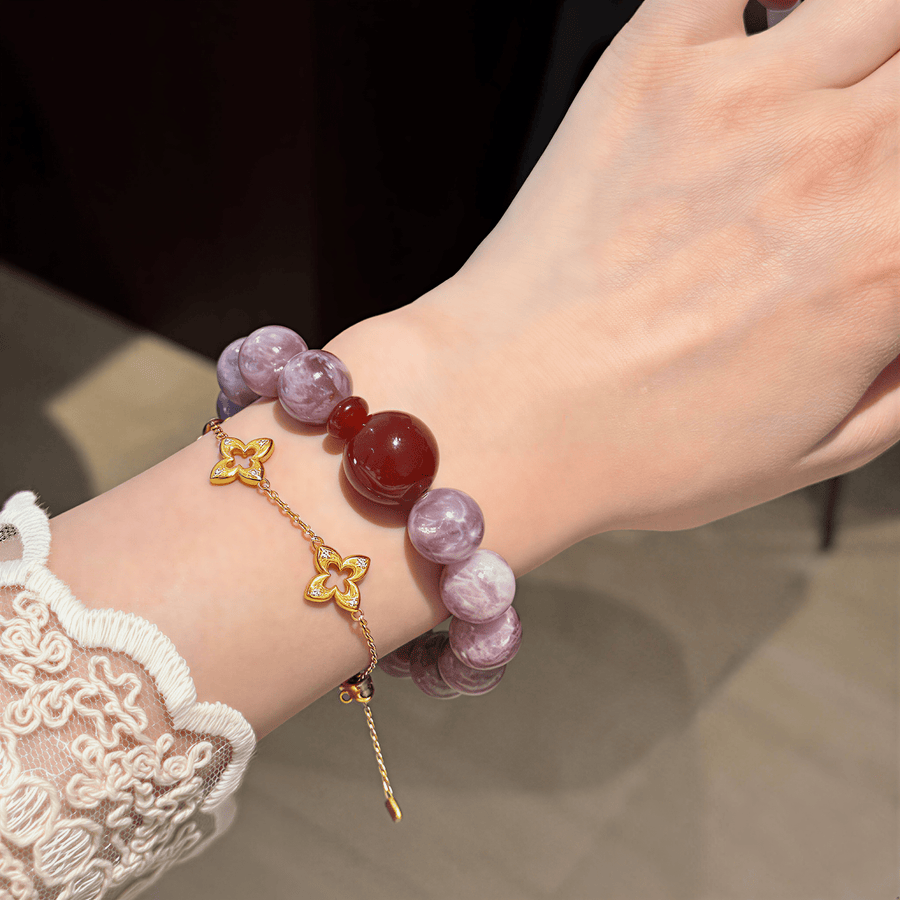 Close-up of a woman wearing I Trust My Fire bracelet with 12mm Amethyst beads and a red centerpiece