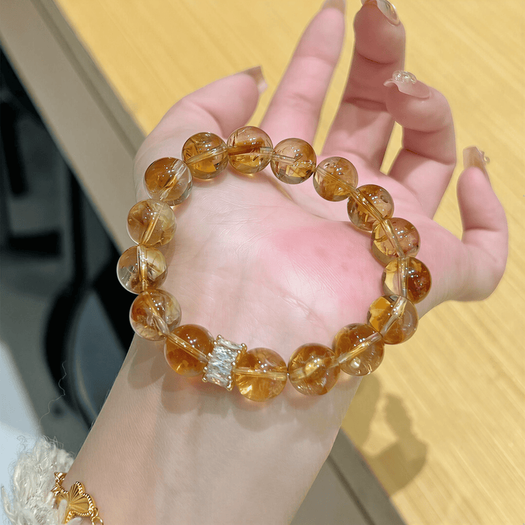 I Welcome More Citrine bracelet held in hand showing golden 10mm natural Citrine beads