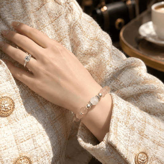 Woman wearing Love Lives Here Rose Quartz bracelet with cream textured jacket
