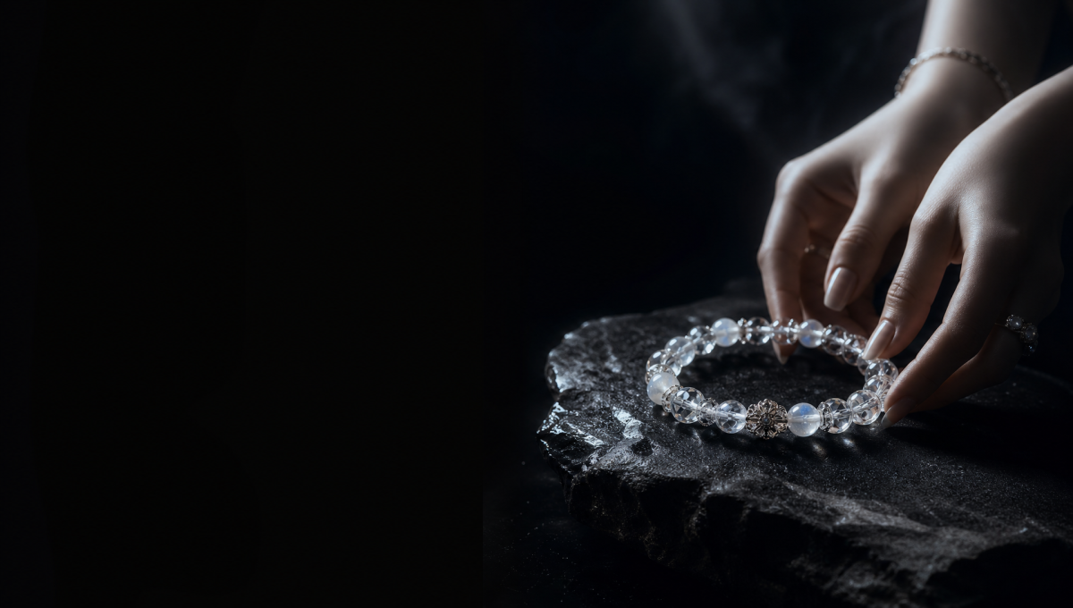 Hands placing a crystal bracelet on a black stone for a cleansing and recharge ritual