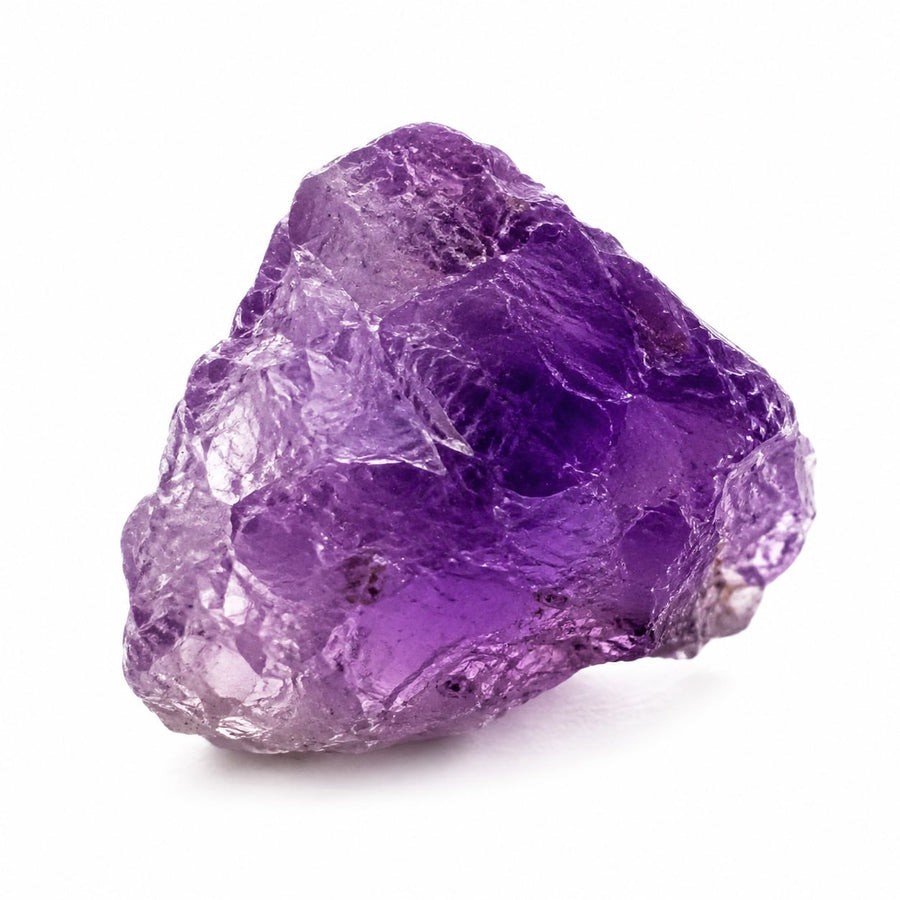 Raw purple amethyst crystal on a white background