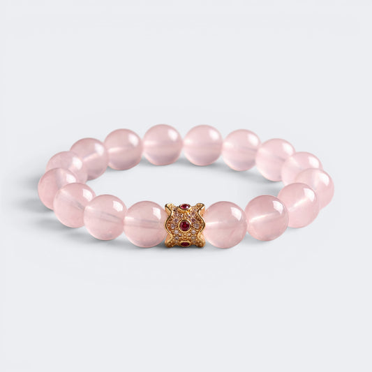 Front view of My Heart Is Safe bracelet with 10mm natural Rose Quartz beads and gold-tone ruby-red charm