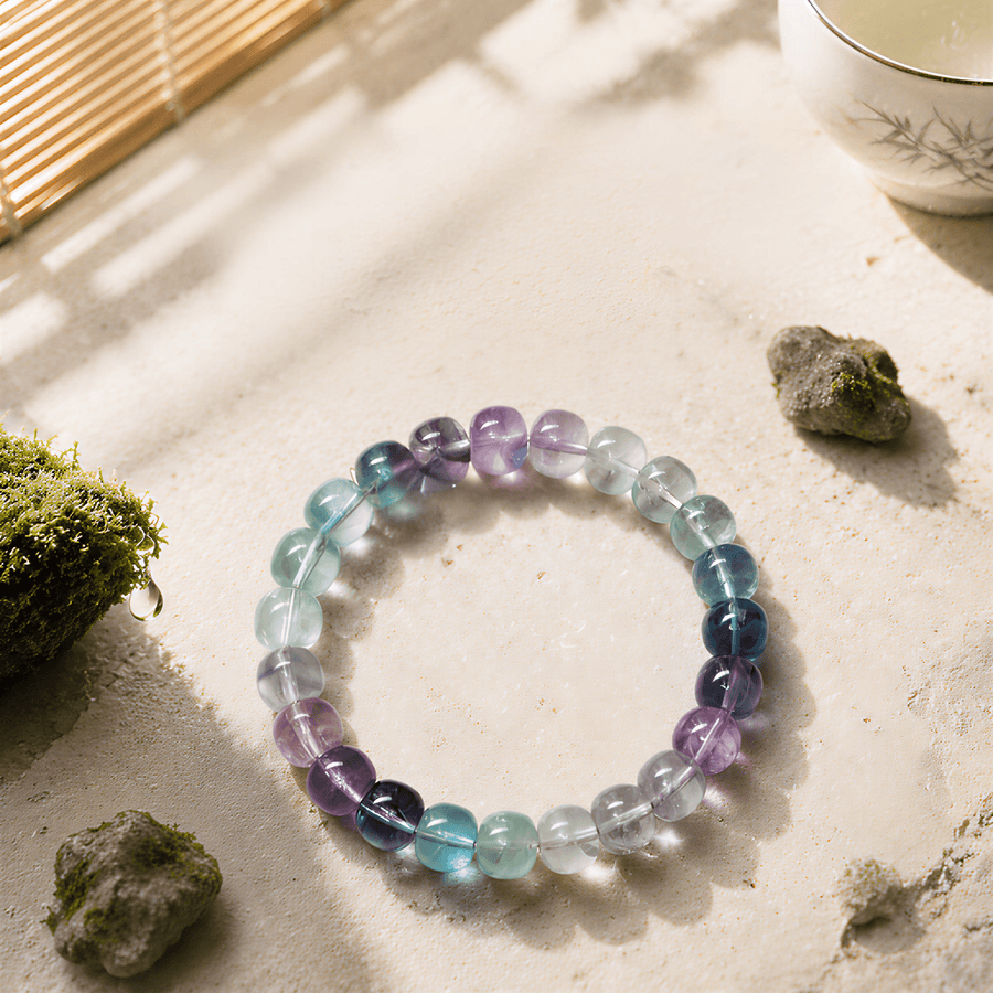 High-clarity Rainbow Fluorite bracelet displayed with moss and stones in sunlight