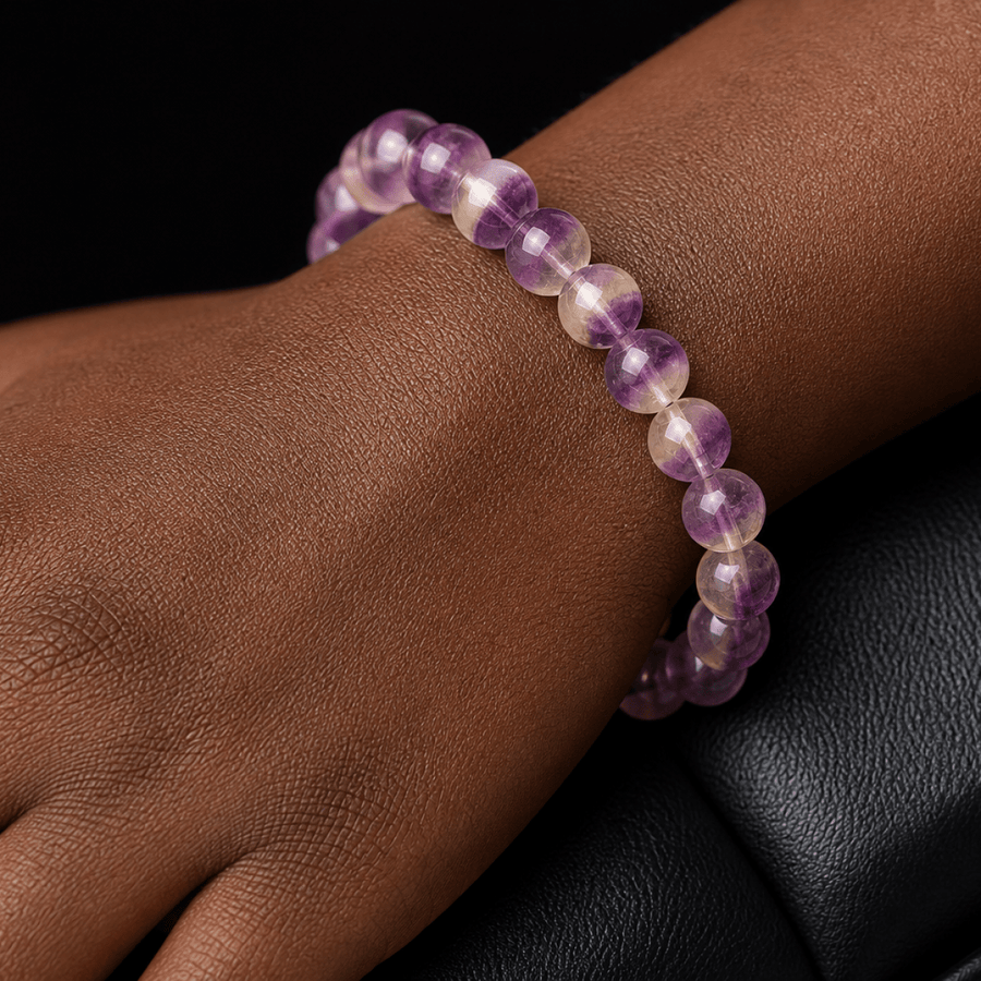 Close-up of natural Purple Fluorite beads worn against a black background