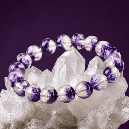 Purple Fluorite bracelet displayed on a white crystal cluster against a violet background