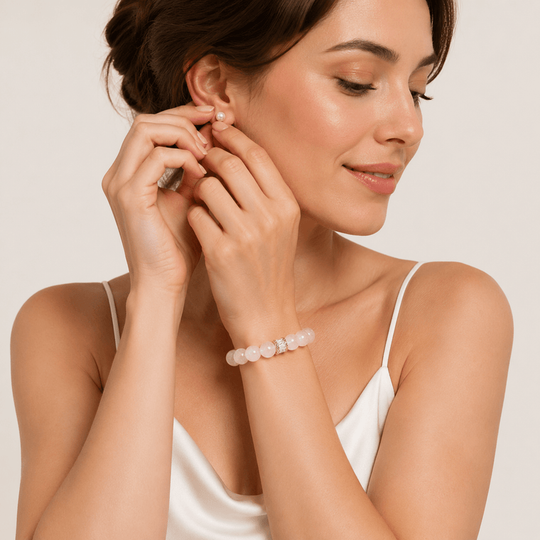 Woman wearing Soft Devotion Rose Quartz bracelet with a white satin slip dress