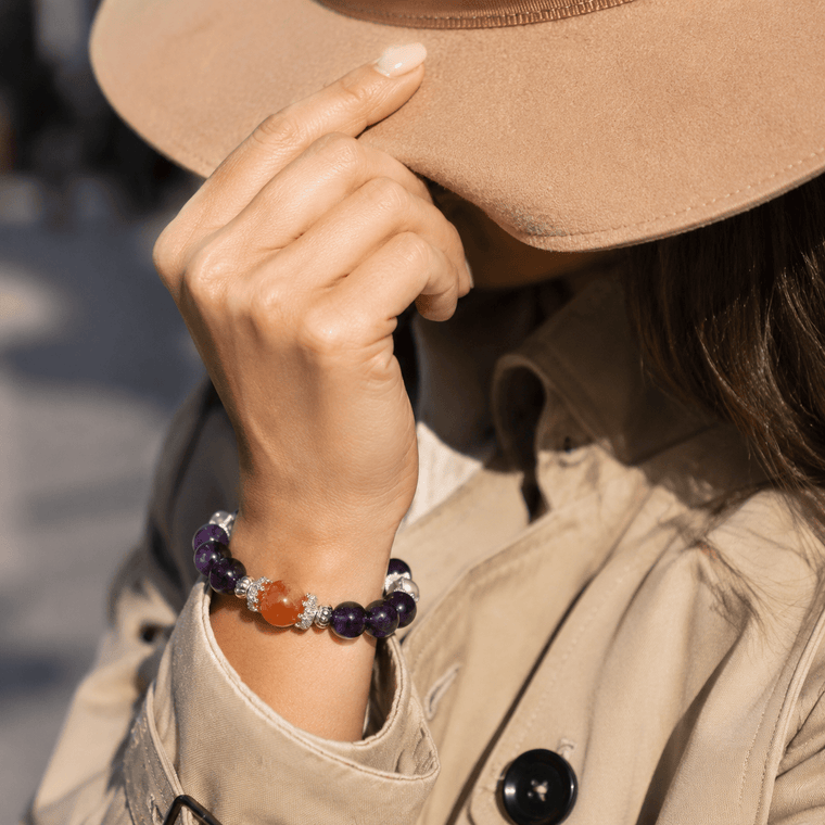 The Courage to Bloom Amethyst bracelet worn with a beige trench coat