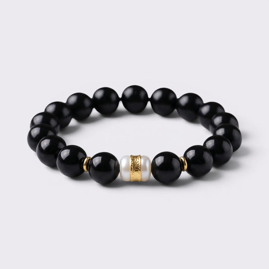Front view of The Way Opens bracelet with 12mm natural Obsidian beads and Six-Syllable Mantra turning bead centerpiece