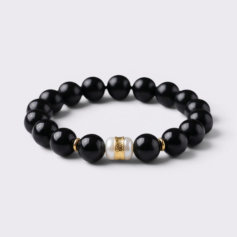 Front view of The Way Opens bracelet with 12mm natural Obsidian beads and Six-Syllable Mantra turning bead centerpiece
