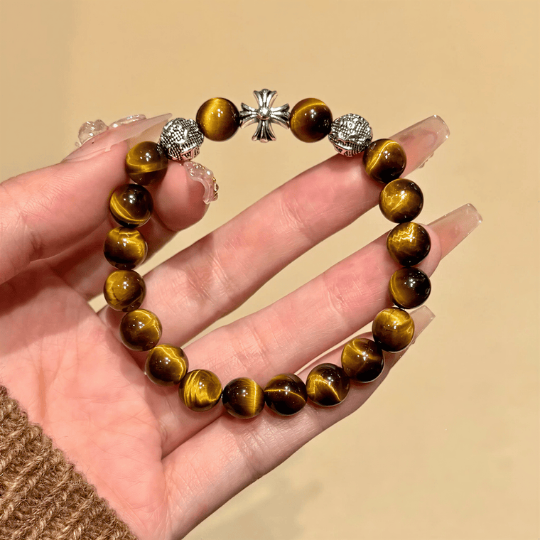 Close-up of Tiger's Eye beads with silver-tone cross and textured metal accents