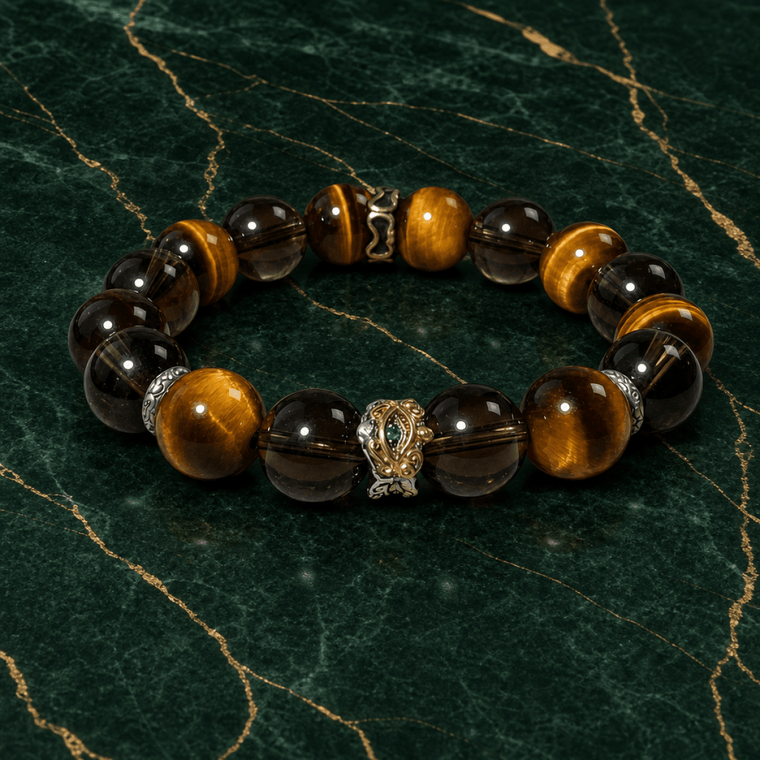 Tiger’s Eye and Smoky Quartz stretch bracelet displayed on green marble with gold veining