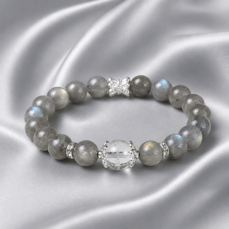 Blue Gray Moonstone bracelet with Clear Quartz focal bead displayed on silver satin fabric